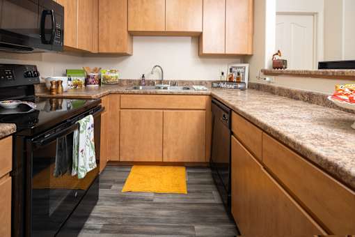 A kitchen with wooden cabinets and a black stove top.