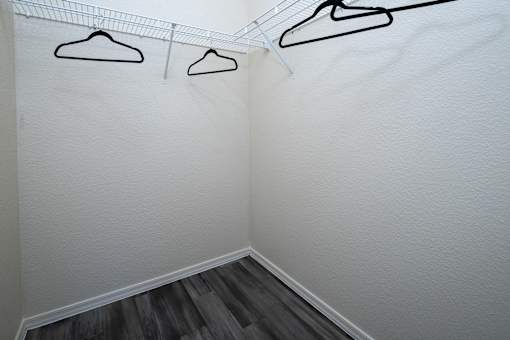 Three hangers are hanging on a wire on a white wall.