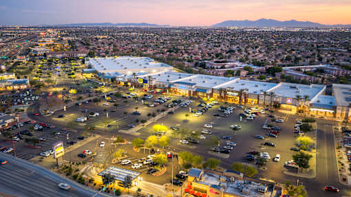 A parking lot with cars and a building in the background.