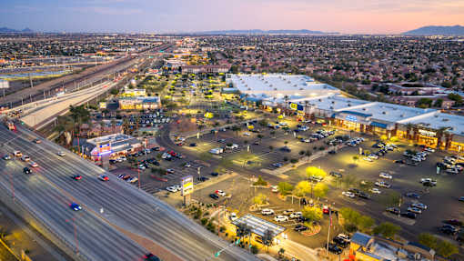 A busy highway interchange with a parking lot and buildings in the foreground.