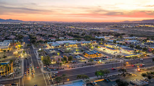 A cityscape at dusk with a view of a highway intersection and buildings.