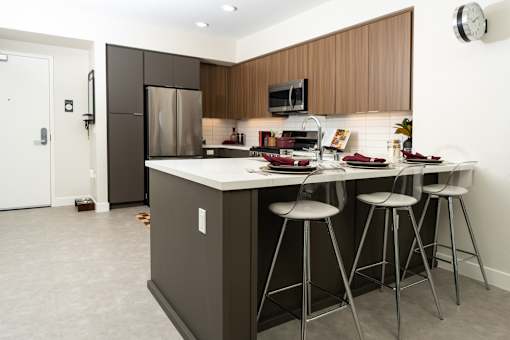 A kitchen with a white counter top and a white fridge.