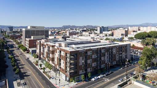 A city street with apartment buildings and cars at Wilshire Valencia Apartment, Los Angeles
