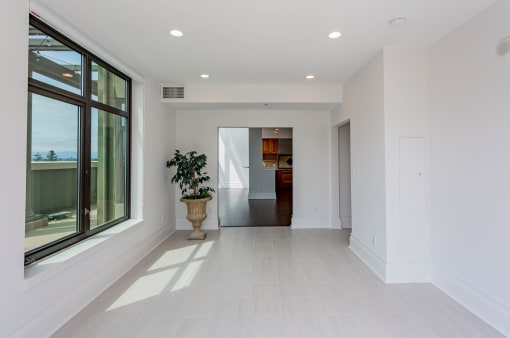 a large white room with a large window and a potted plant at Vendome Place, San Jose