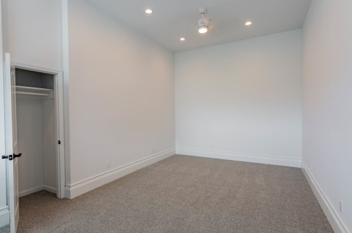 a empty room with white walls and carpet and a closet at Vendome Place, California