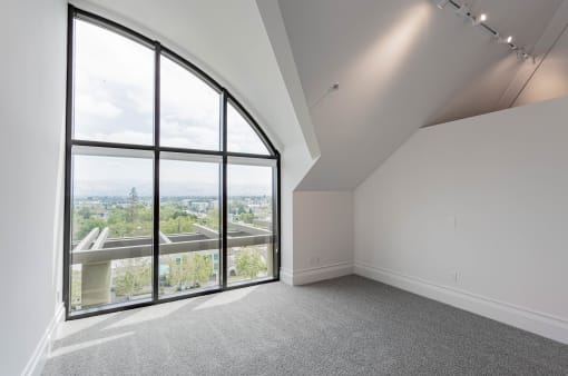 an empty room with large windows and a view of the city at Vendome Place, San Jose, California