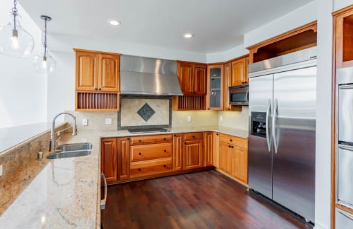 a kitchen with wooden cabinets and stainless steel appliances at Vendome Place, San Jose, CA