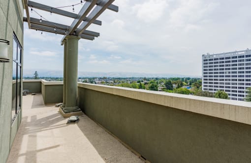 Studios in Downtown San Jose, CA - Vendome Place - Terrace with City View, Pillars, and String Lights.