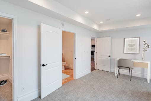 a living room with white doors and a carpeted floor at Vendome Place, California