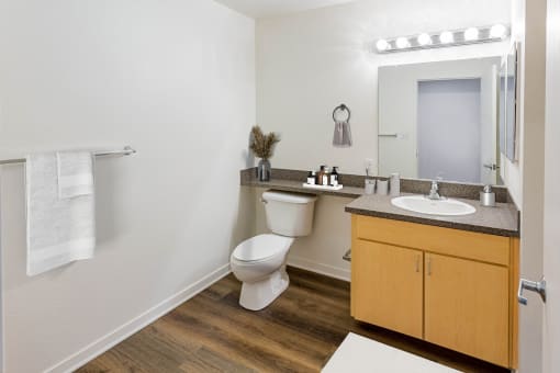 a bathroom with a toilet and a sink and a mirror at Vendome Place, San Jose, CA