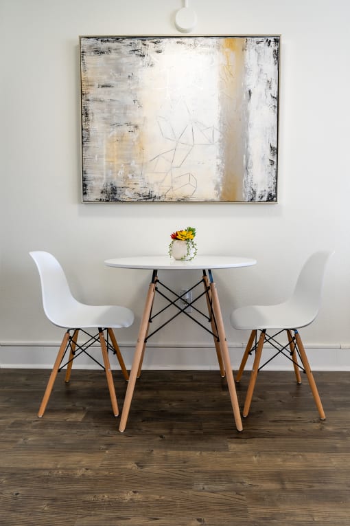 White Chairs and table with artwork on the wall at Vera Cortez Hill, San Diego, 92101