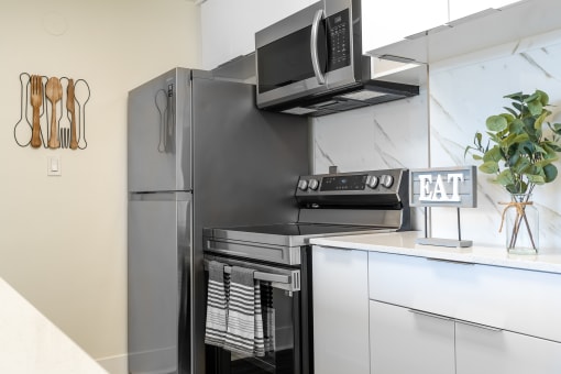 Kitchen with white cabinets with stainless appliances at Vera Cortez Hill, San Diego, CA
