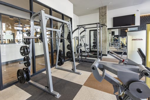 a gym with weights and a tv on the wall at Waterford RiNo, Denver, Colorado