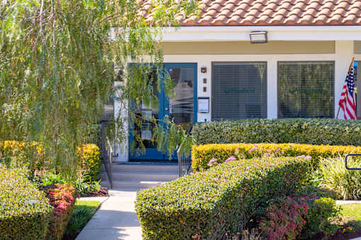 Office entrance with flowers and foliage at Woodbend Apartments, California, 91701