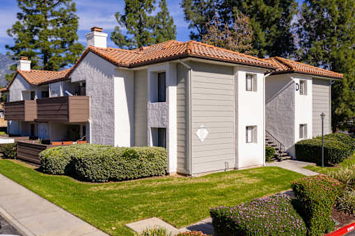 Residential building with balconies and green lawn at Woodbend Apartments, Alta Loma, California