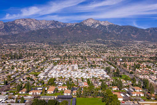 Aerial view of residential community with mountain backdrop at Woodbend Apartments, California, 91701