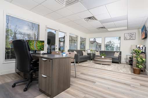 Leasing office with desk and lounge seating at Woodbend Apartments, California, 91701