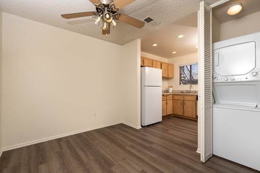 Open concept living area with kitchen and stacked washer dryer at Woodbend Apartments, California, 91701