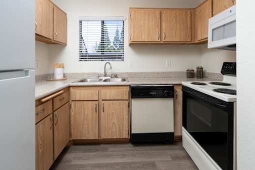 Kitchen with oak cabinets and granite countertops at Woodbend Apartments, Alta Loma, 91701