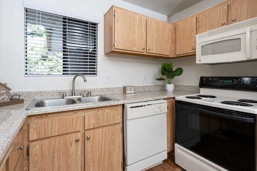 Kitchen with oak cabinets and electric stove at Woodbend Apartments, Alta Loma, CA