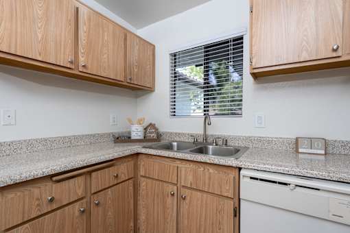 Kitchen corner with double sink and window at Woodbend Apartments, Alta Loma, 91701