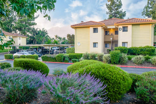 Building exterior and covered parking at Woodbend, Alta Loma, 91701