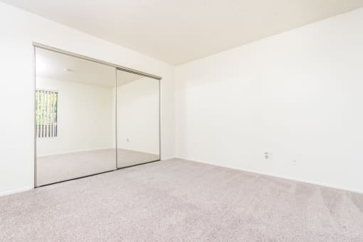 Bedroom with large mirror and closet at Woodbend, Alta Loma, California