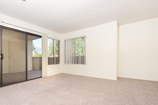 Living room with windows and balcony door at Woodbend, Alta Loma, CA