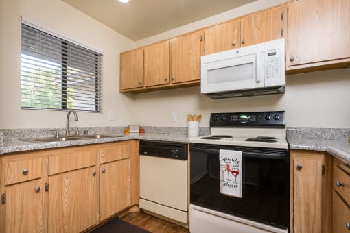 Kitchen with appliances and a window at Woodbend, California, 91701