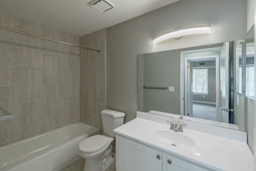 a bathroom with a large mirror and a sink and a toilet