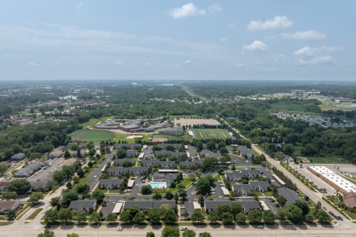 an aerial view of a suburban neighborhood with houses and lawns and trees