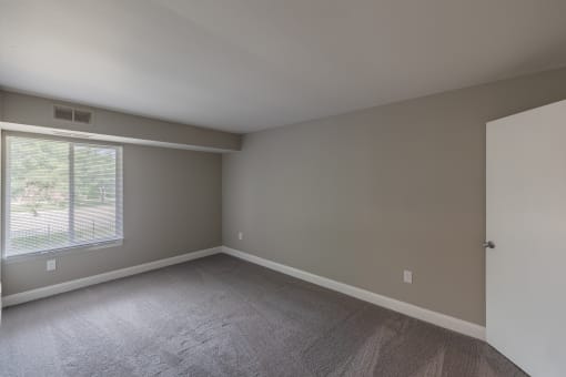 an empty room with a window and a door