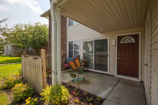the front porch of a house with a patio and a wooden fence