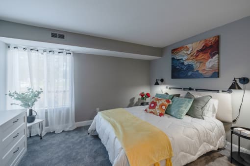 a bedroom with a bed and a painting on the wall