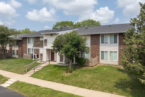 an apartment building with a lawn and a sidewalk