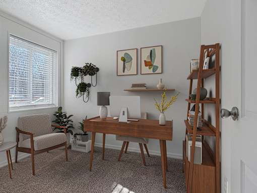A room with a desk, chair, and a plant.