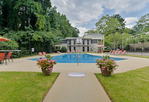 A pool with a house in the background.