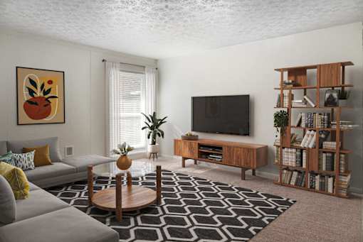 A living room with a grey sofa, a wooden coffee table, a television, and a bookshelf.