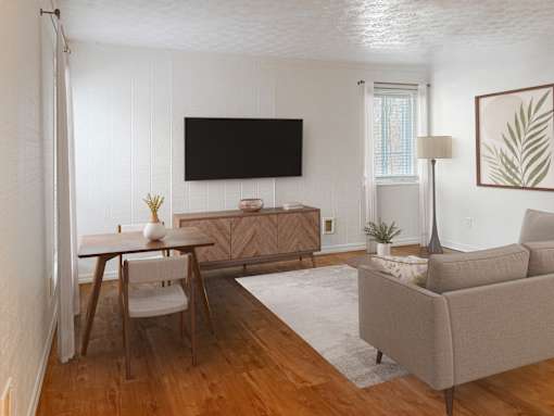 A living room with a couch, chair, and television.