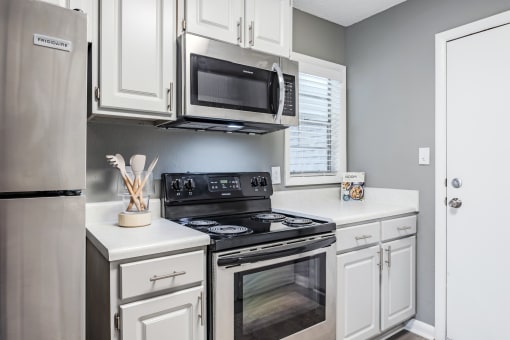 a kitchen with stainless steel appliances and white cabinets