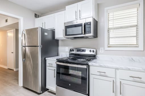 a kitchen with stainless steel appliances and white cabinets