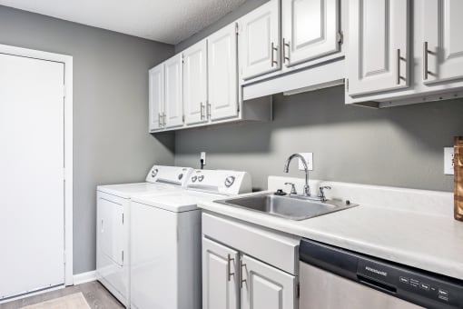 a white kitchen with white cabinets and a sink