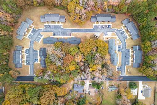 An aerial view of a parking lot surrounded by trees.