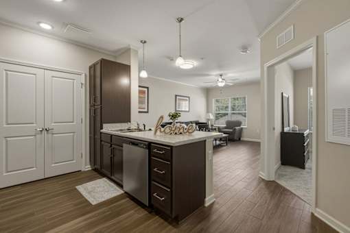 A kitchen with a wooden floor and white walls.