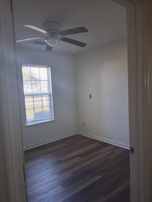 A room with a ceiling fan and a window.