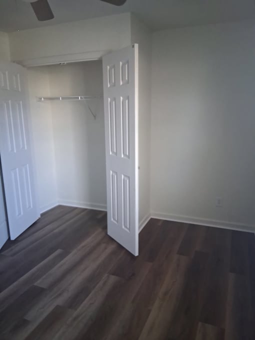 A room with a white door and a ceiling fan.