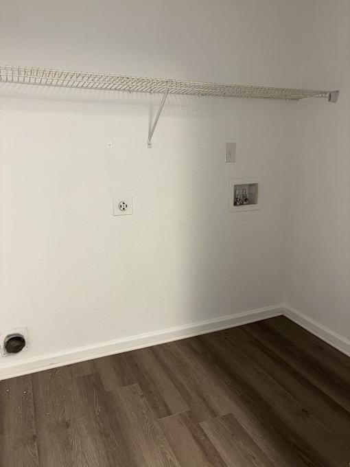 A white wall with a picture frame and a white shelf.