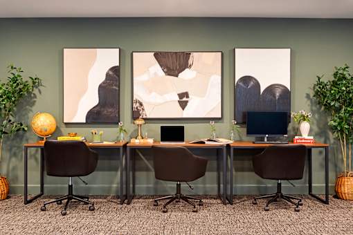 Three chairs are arranged around a table with a laptop and a monitor on it.