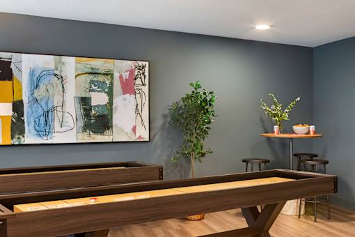 A room with a pool table and a painting on the wall.