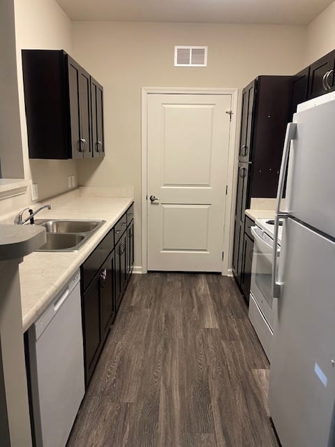 A kitchen with a white door and a white fridge.